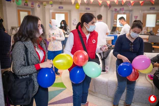 A female volunteer holding balloons